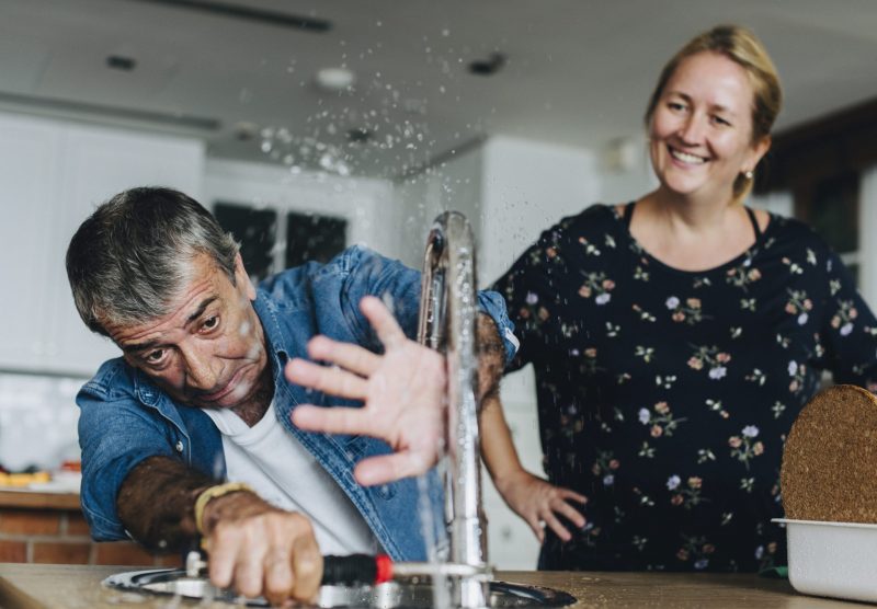  Plumber Maintaining kitchen sink of a women kitchen