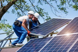 Workers are setting solar panels on home roof