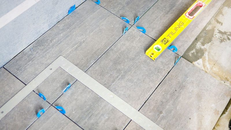 A man is calculating bathroom area to tile it 