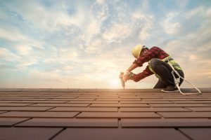 A Professional Roofer Working On Roof