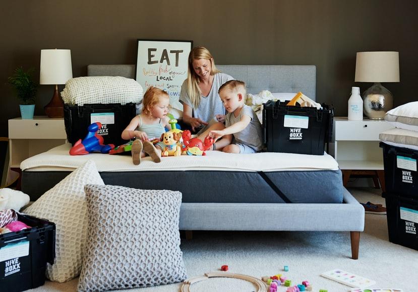 Children and mother all are play with the toys on a bed