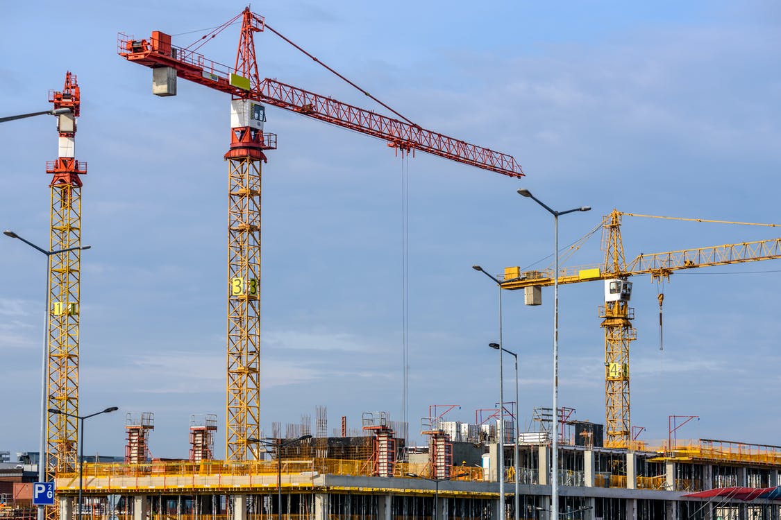 Free Three Yellow and Red Tower Cranes Under Clear Blue Sky Stock Photo