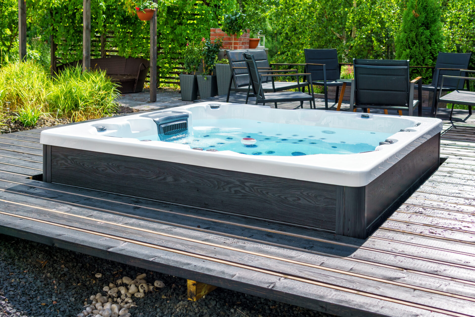 Large hot tub embedded in the backyard terrace. A sunny summer's