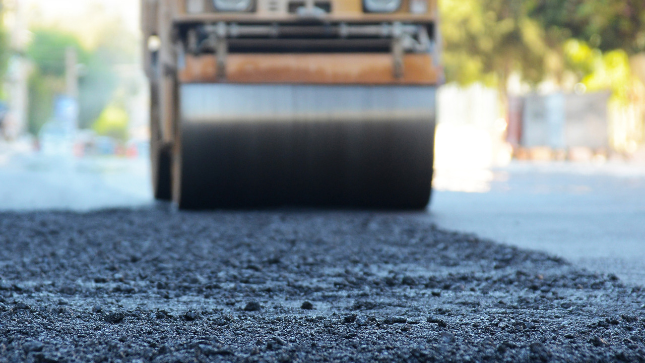 Asphalt concrete being paved and compacted 